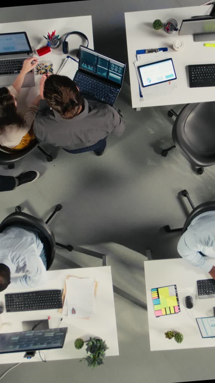 Vertical Video Top down view zoom in of employees collaborating on planning business strategy