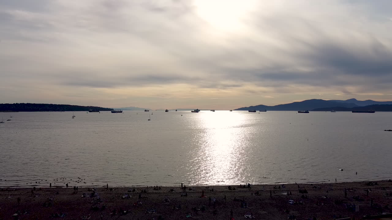 화물선 바지선 화물선이 iport 수출 무역을 위해 줄을 서고 레크리에이션 선박이 1-2 주차 된 상업 산업 항구의 주거 전용 해변 위로 여름 일몰 공중 비행