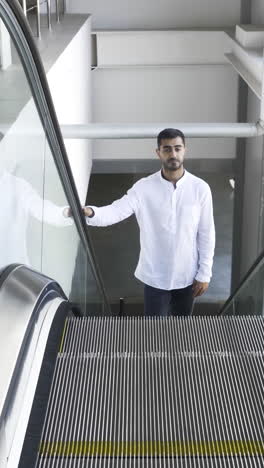 man standing on an escalator in a modern building