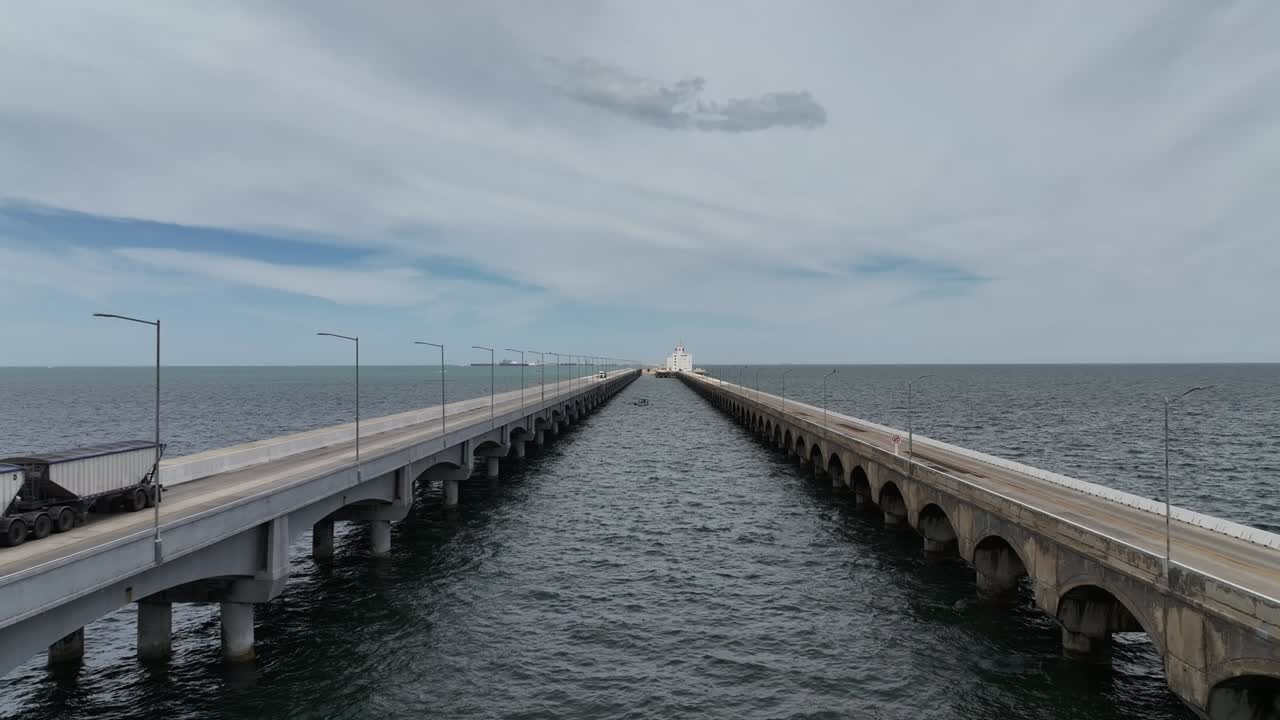 Aerial view of the two parallel lanes of the long bridge that connects Progreso, Yucatán to the remote terminal. A trailer truck drives across the left lane