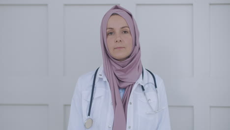 looking at the camera listening woman doctor in hijab looks at the camera and listens to the patient. a video conference listener. portrait of a doctor in a hijab