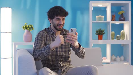 joven usando el teléfono inteligente y regocijándose. ganar dinero, ganar apuestas, recibir buenas noticias.