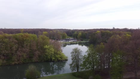 drone-shot-of-a-coffee-by-a-lake-in-a-beautiful-park-in-good-weather