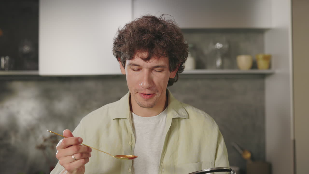 Man Tasting Food While Cooking in the Kitchen