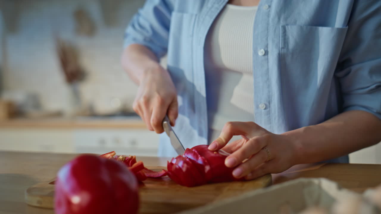 Girl hands slicing ingredients for salad at kitchen closeup. Young woman cooking