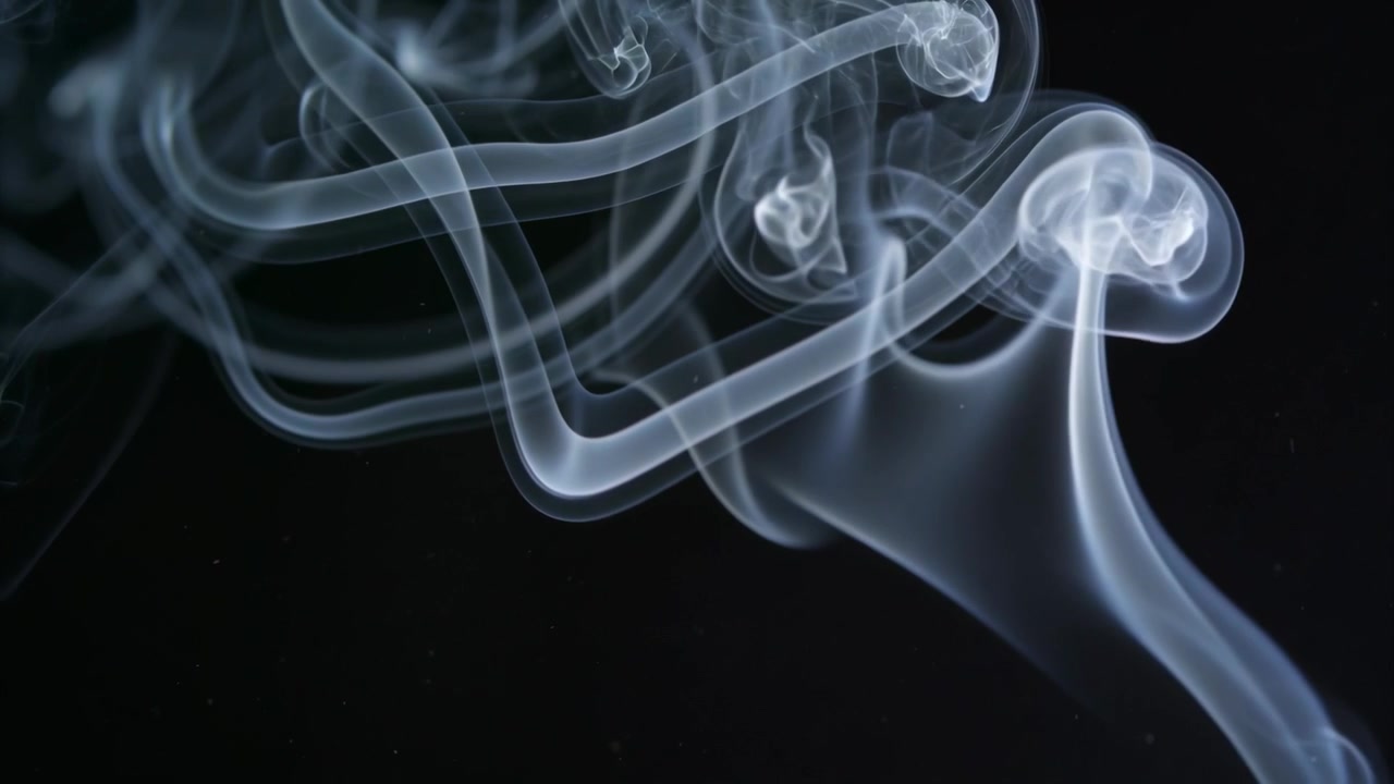 Una colonna di fumo traslucido emerge e sale dal quadrante inferiore destro in uno studio buio, formando nastri