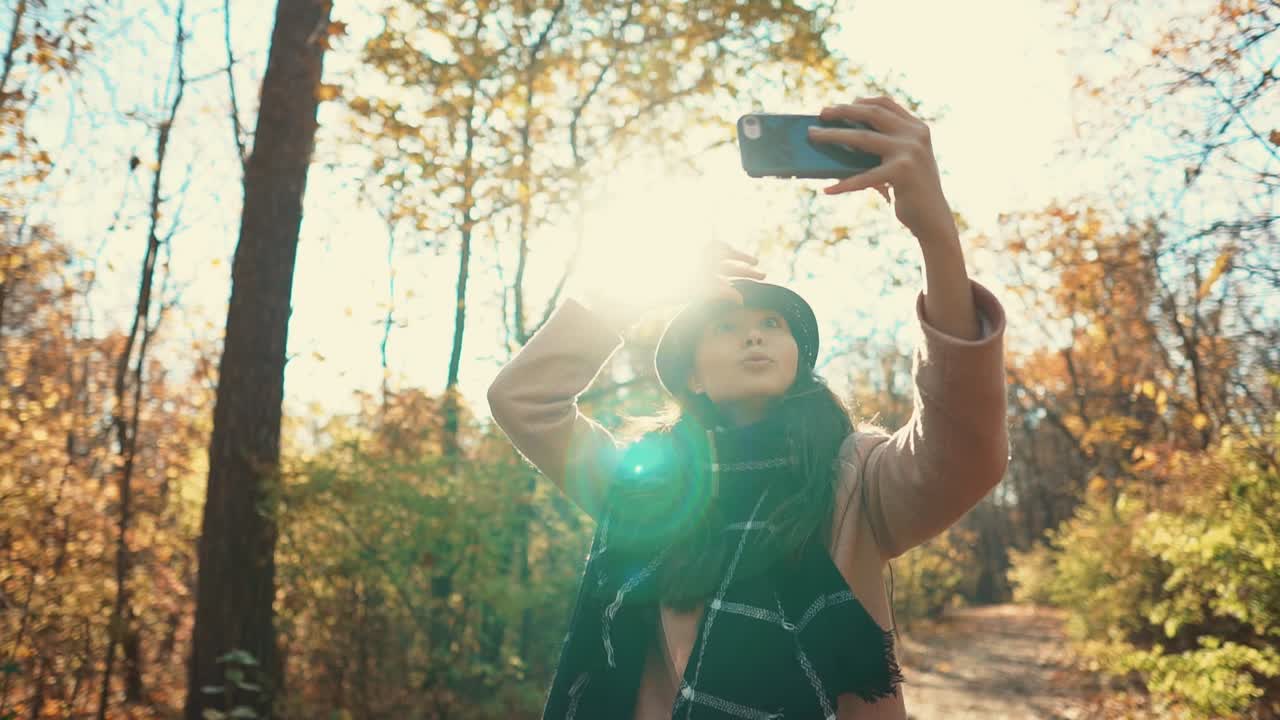 mujer tomando una selfie en el bosque de otoño