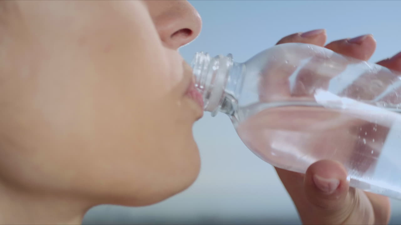 야외 에서 요가 훈련 을 한 후 물 을 마시는 여자. 운동 을 한 후 휴식 하는 소녀