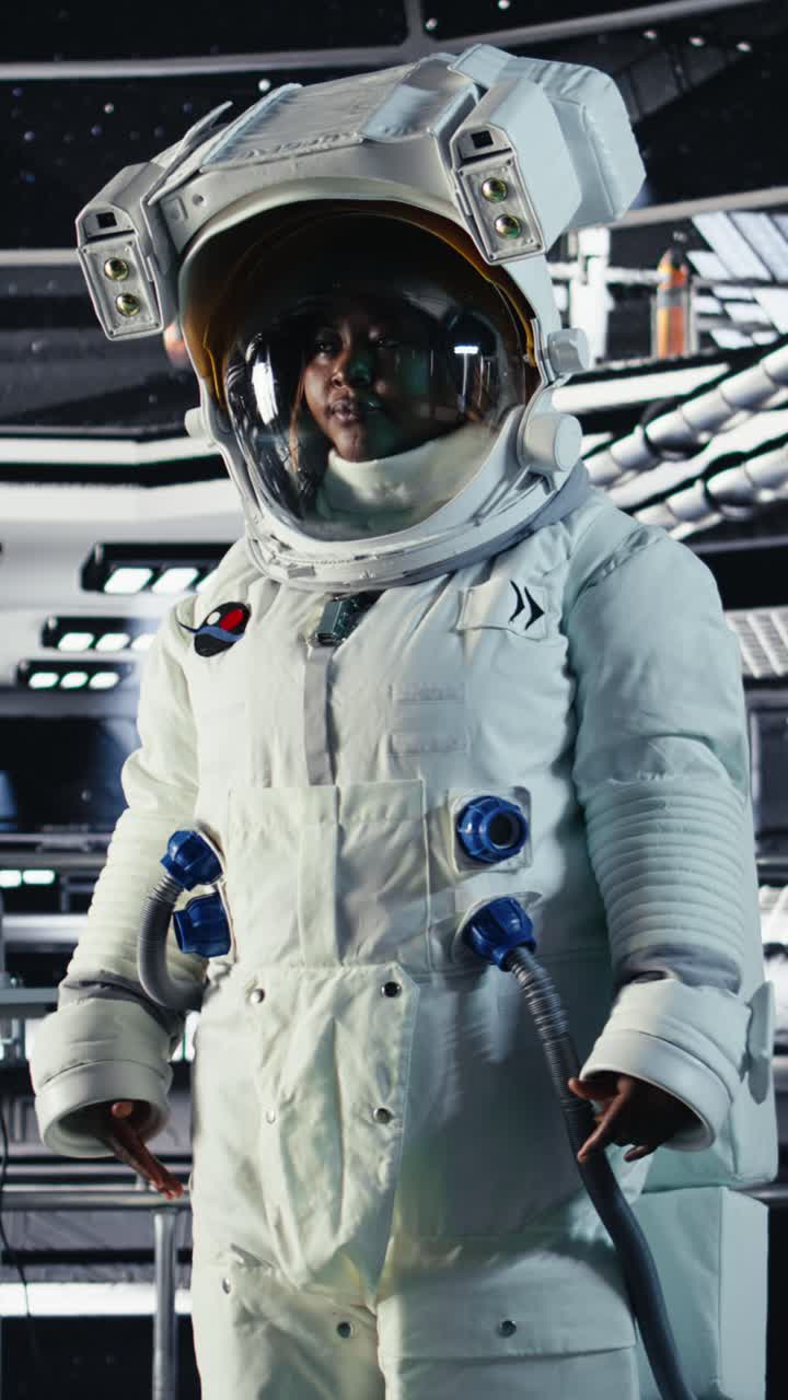 Vertical video Portrait of smiling astronaut inside high tech spacecraft