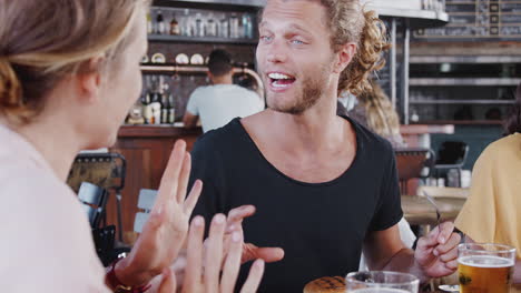 group of young friends meeting for drinks and food in restaurant