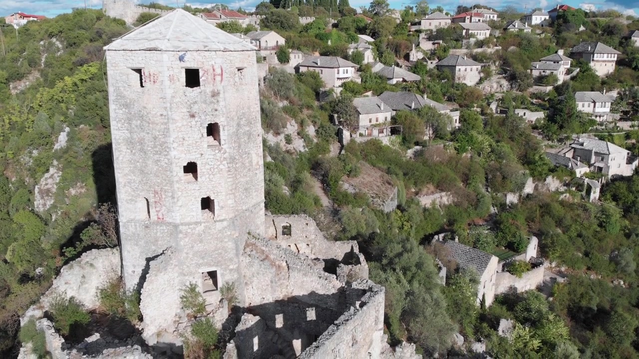 Ripresa aerea: drone che vola vicino alla torre nella fortezza di Počitelj, in Bosnia ed Erzegovina. In discesa.