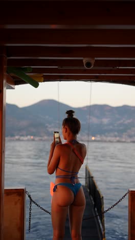 woman in bikini taking photo on a boat