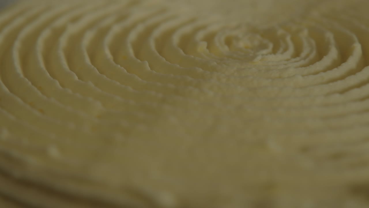 primer plano extremo de la parte superior de un pastel giratorio, decorado con un diseño helado en espiral