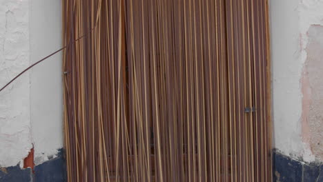 primer plano de una vieja puerta de madera con una cortina de caña