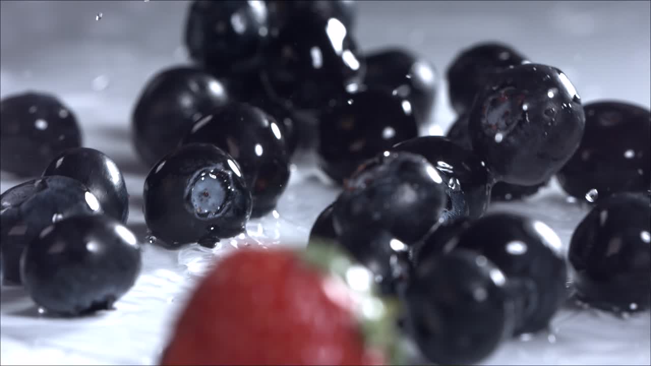 블루베리와 딸기가  바탕에 굴러 내려오고 있습니다. 느린 동작