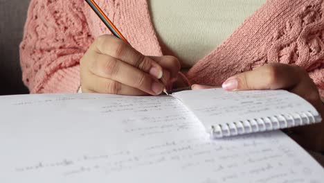 Close-up-of-women-hand-writing-on-notepad