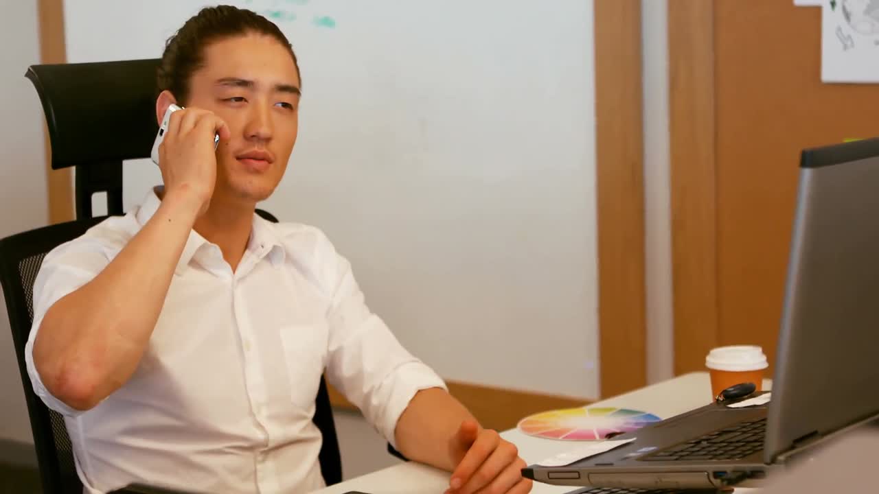 그래픽 디자이너가 휴대폰으로 이야기하고 있습니다.