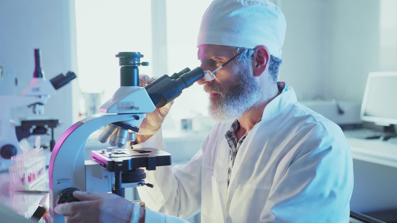 Male Scientist Working with Microscope and Laptop in Laboratory