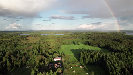 stunning rainbow over beautiful serene forest and lake landscape in finland, near kuopio