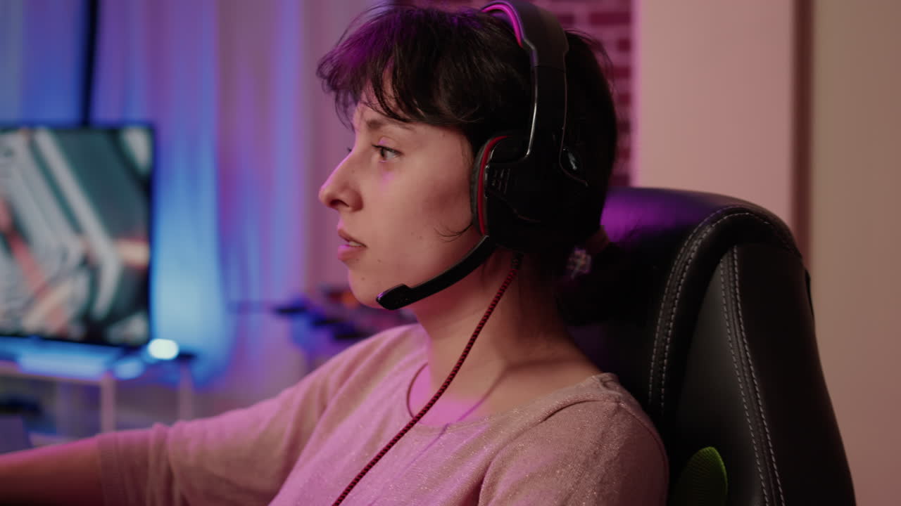 Closeup of woman with gaming headset playing multiplayer first person shooter streaming gameplay