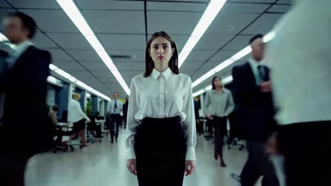 professional businesswoman standing motionless amid blurred colleagues moving quickly through modern corporate hallway, highlighting workplace dynamic