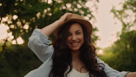 portrait of happy woman turning around during walk at park road