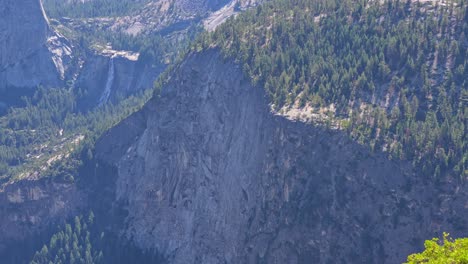 footage capturing a dramatic steep mountain cliff in yosemite national park, california, with the scenic nevada fall visible in the background.