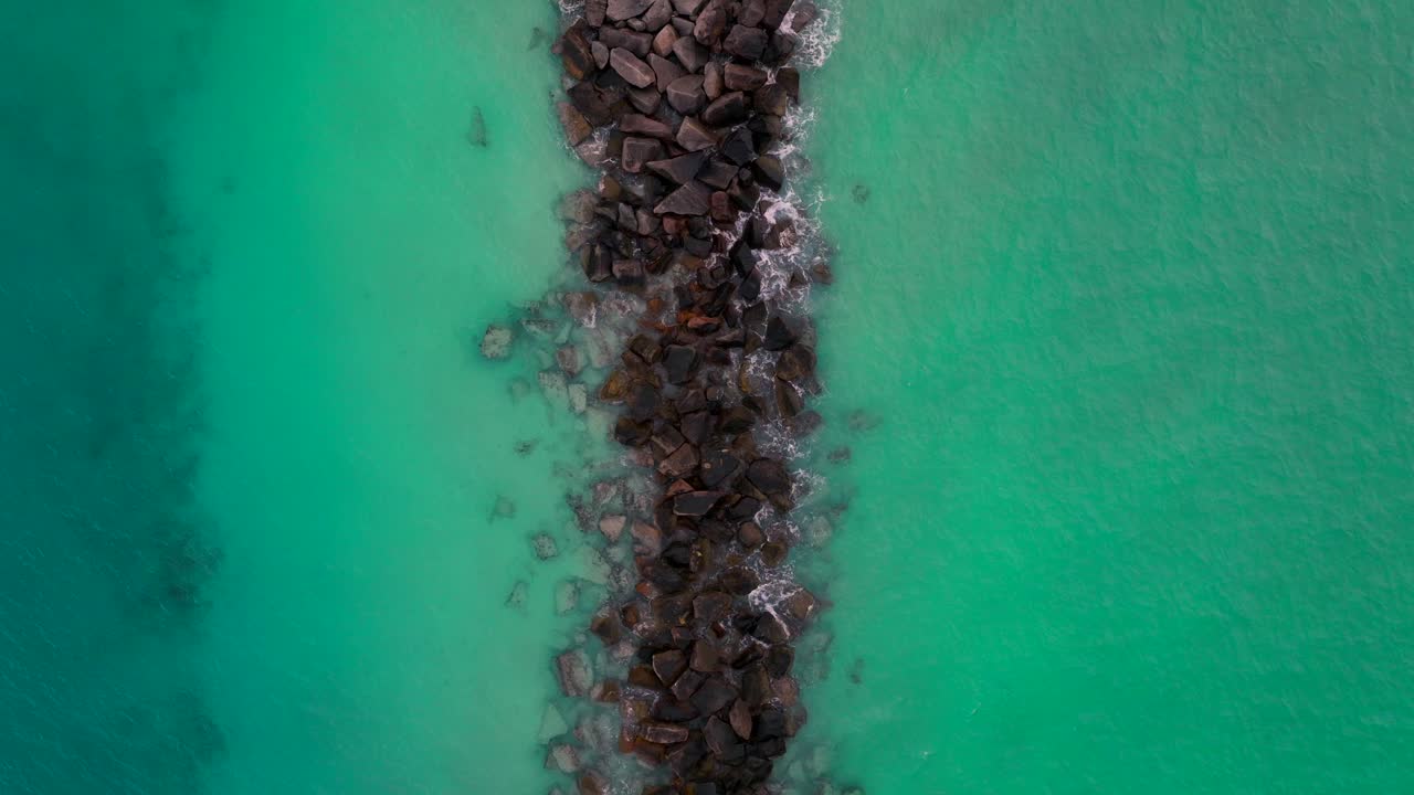 olas de playa golpeando rocas del muelle