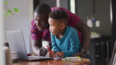 Video-of-happy-african-american-father-helping-son-in-homework