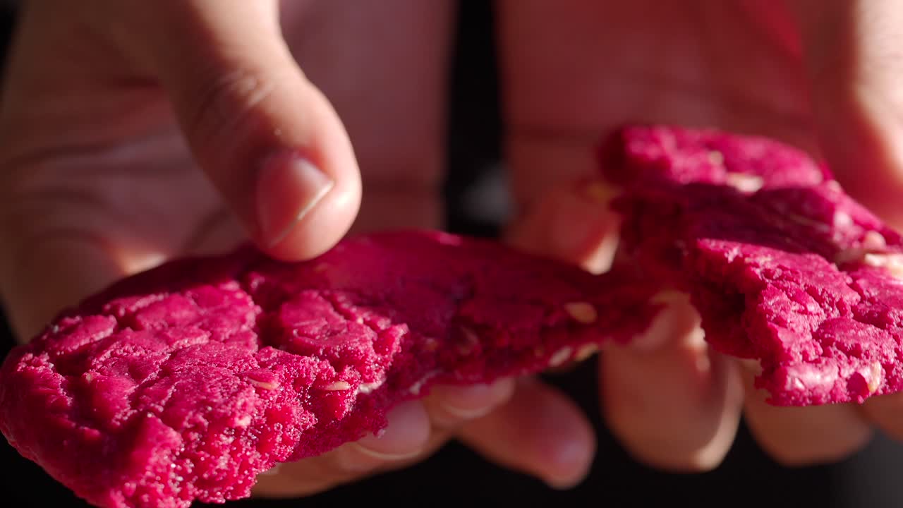 manos sosteniendo una galleta rosa rota