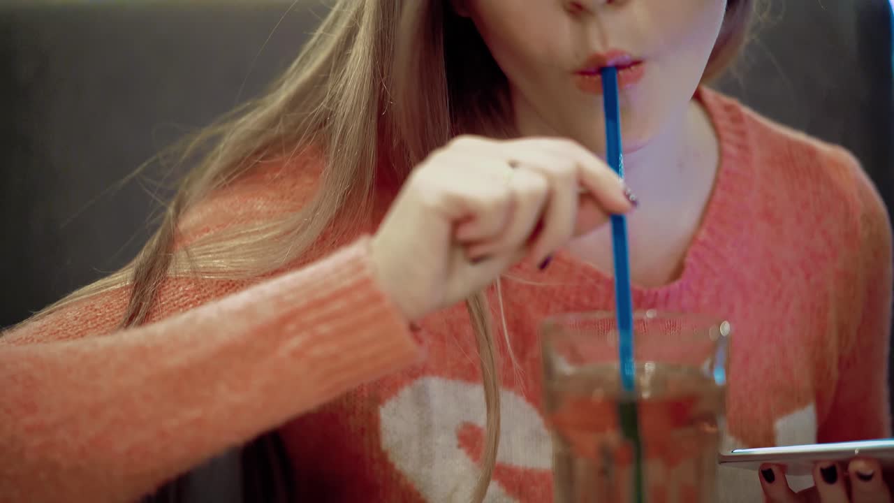 una joven hermosa está sentada en un café.