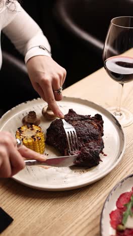 woman eating steak dinner in a restaurant