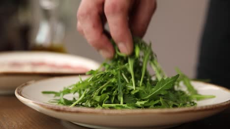 chef preparing a salad with arugula