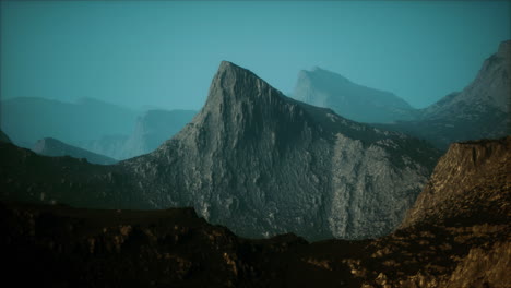 silhouette of swiss alps mountains in morning clouds