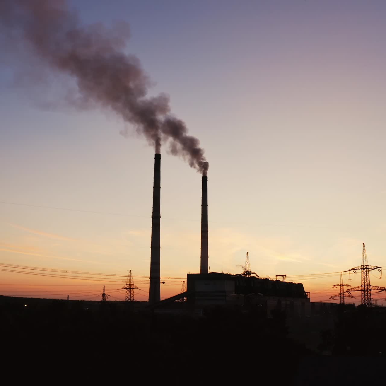 Smoke coming from pipes from factory at darkness. Chemical smoke going into the air from industrial pipes in the city.