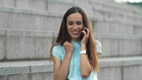 Businesswoman-having-conversation-on-smartphone-outside.Girl-celebrating-victory