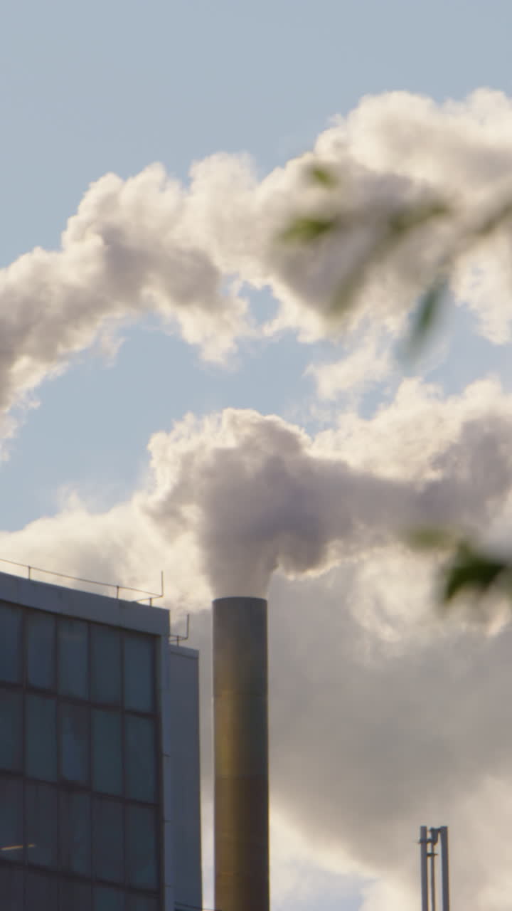 Harmful gas emissions from factory chimneys adds to climate crisis. Vertical