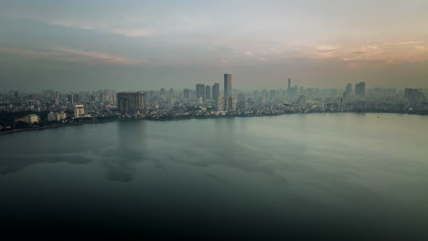 by ho tay lake, the city stands, with buildings rising, shaped by hands