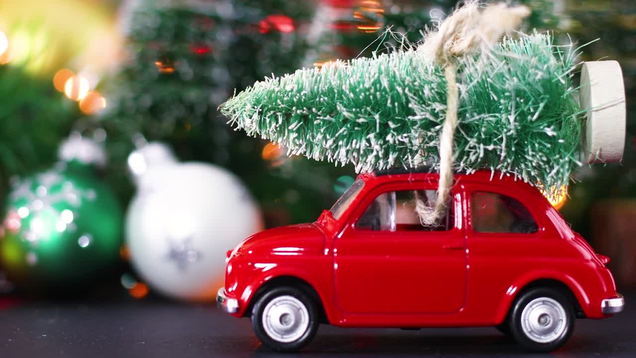 Decorazione natalizia invernale con auto rossa d'epoca con albero di Natale sul tetto e luci intermittenti sulla decorazione
