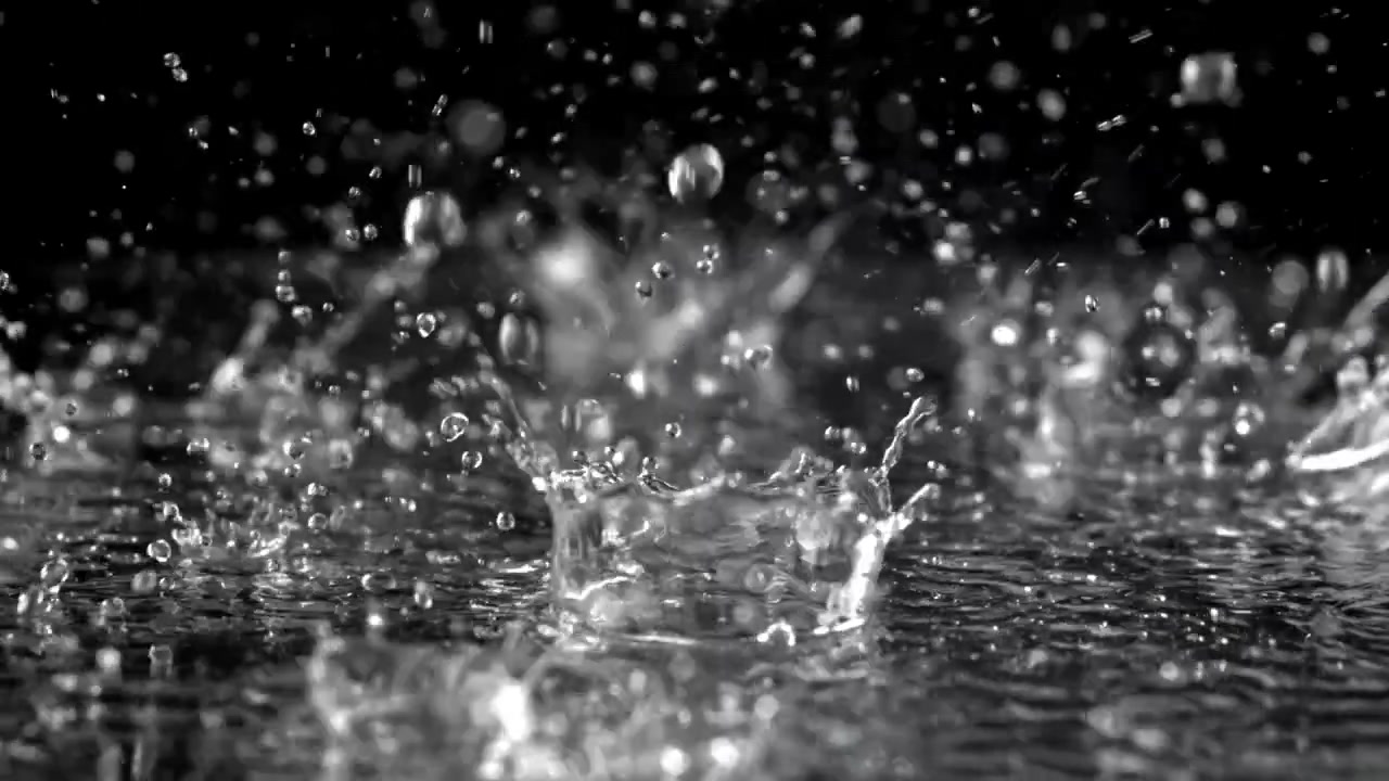 Clear Water Droplets Splashing in Slow Motion Against a Black Background