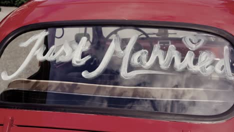 "just married" written on a rear window of an old car