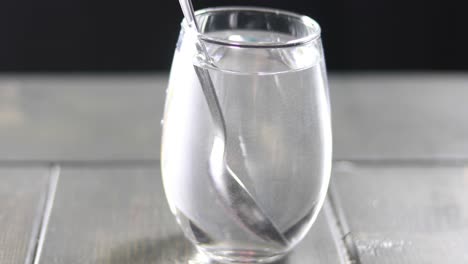 mezclar tinte rojo en un vaso de agua con una cuchara