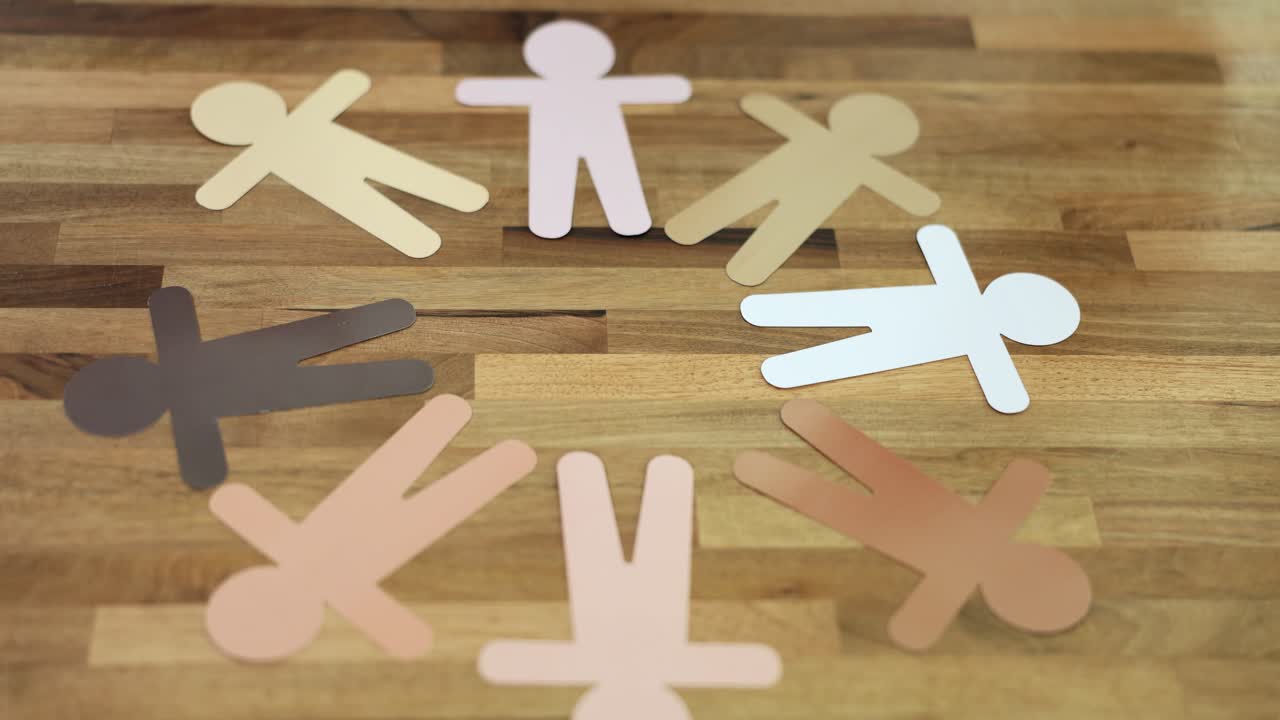 Paper different human figures making circle on table
