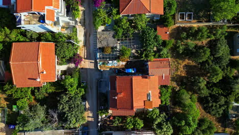 Private-homes-with-colorful-rooftops-of-Greek-township,-aerial-top-down-view