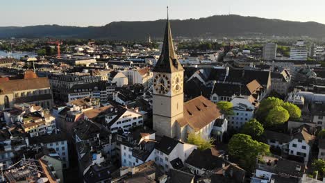 Aerial-view-of-Zurich,-Switzerland-at-sunset-with-rising-motion-over-St