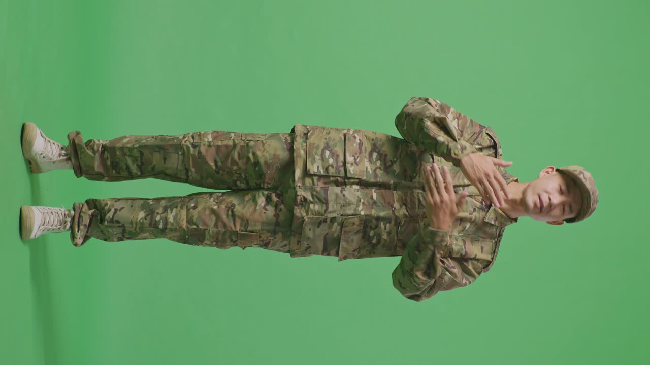 Full Body Of Wondering Asian Man Soldier Saying Why And Standing Doubtfully In The Green Screen Background Studio