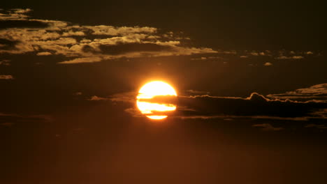 Ein-Leuchtend-Orangefarbener-Himmel-Verdunkelt-Sich,-Während-Die-Sonne-Unter-Den-Horizont-Verschwindet