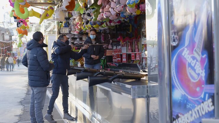 Persone che giocano a giochi di tiro al luna park