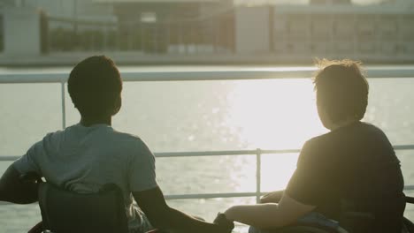 Feliz-Pareja-En-Silla-De-Ruedas-Saliendo-En-El-Muelle-Por-La-Noche