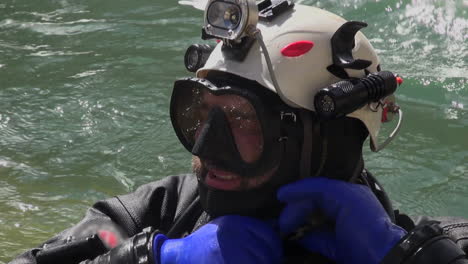 primer plano: buzo tecnológico barbudo sin casco en el agua turbulenta del río